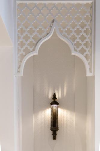 a light in a room with a wall with a ceiling at Hotel Casa Palacio Don Ramón in Seville