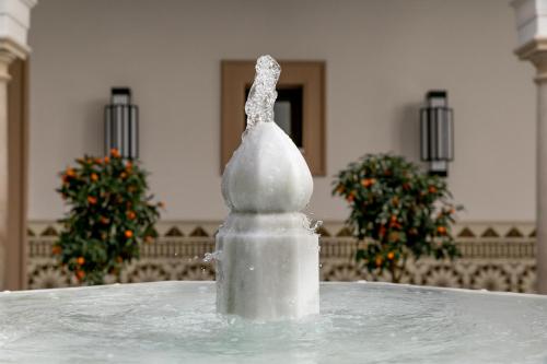 a statue of a chicken sitting on top of a fountain at Hotel Casa Palacio Don Ramón in Seville