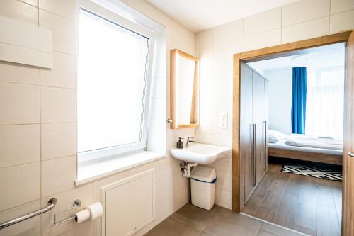 a bathroom with a sink and a window at Hotel Squash Dependance in Prievidza