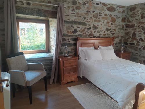 a bedroom with a bed and a chair and a window at Casa do Poço - Douro in Peso da Régua