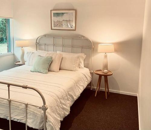 een slaapkamer met een bed en een lamp op een tafel bij Blairgowrie Beach what a spot Relax in private in Blairgowrie