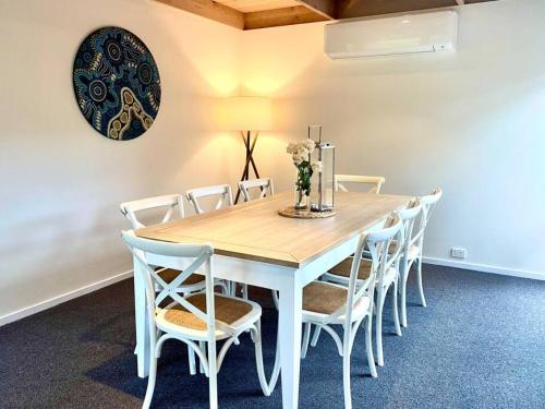 a dining room with a white table and chairs at Blairgowrie Beach what a spot Relax in private in Blairgowrie