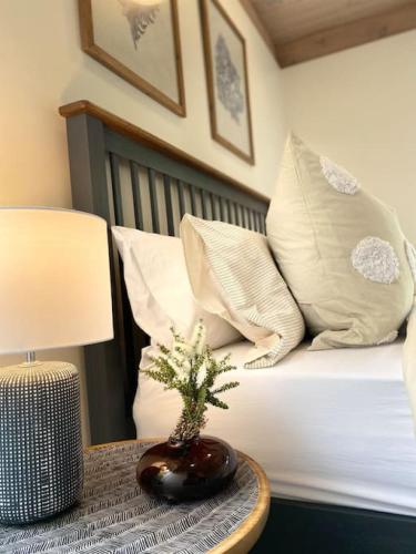 a bedroom with a bed with pillows and a table with a lamp at Blairgowrie Beach what a spot Relax in private in Blairgowrie