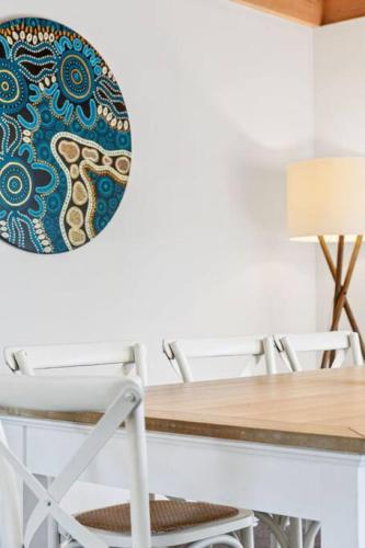 a dining room table and chair with a plate on the wall at Blairgowrie Beach what a spot Relax in private in Blairgowrie