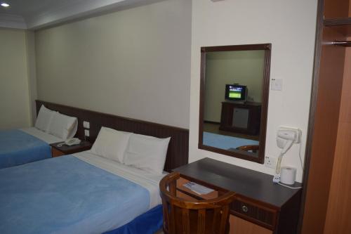 a hotel room with a bed and a mirror at Federal Hotel Kangar Perlis in Kangar