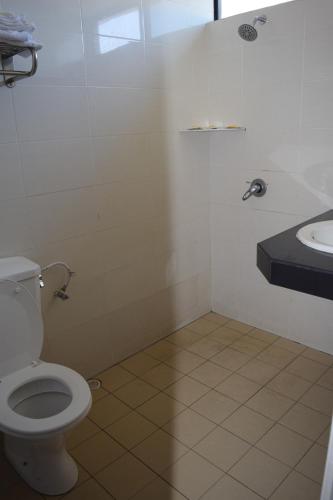 y baño con aseo y lavamanos. en Federal Hotel Kangar Perlis en Kangar