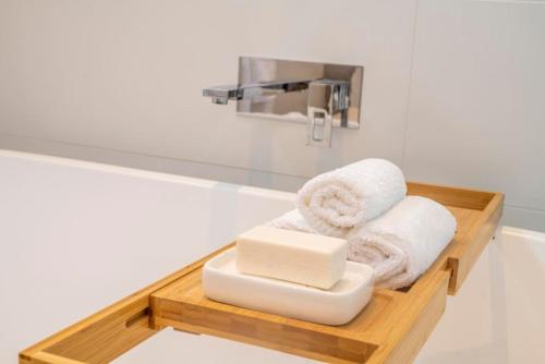 Sorrento Luxe - Resort Style Luxury in Sorrento في سورينتو: حمام مع صينية خشبية مع مناشف ومغسلة