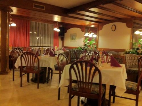 ザンクト・ゲオルゲン・イム・アッターガウにあるガストホフ ペンション シュタインベルガーのテーブルと椅子が備わるレストラン