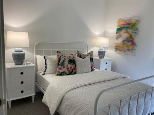 Sorrento Luxe - Resort Style Luxury in Sorrento في سورينتو: غرفة نوم بها سرير وطاولتين جانبيتين ومصباحين