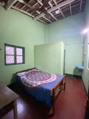 ein Schlafzimmer mit einem Bett in der Ecke eines Zimmers in der Unterkunft Castellos tourist nest in Benaulim