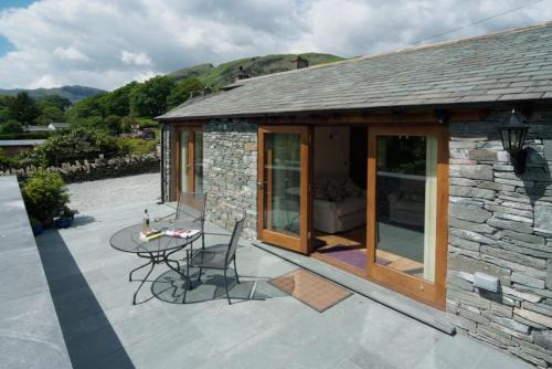 a patio with a table and a stone building at Damson View, Little Langdale in Little Langdale