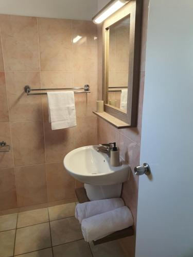 a bathroom with a sink and a mirror at Larnaca Bay Suites in Larnaka
