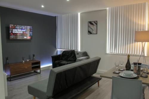 ein Wohnzimmer mit einem Sofa und einem Tisch in der Unterkunft Modern Bradford City Apartment in Bradford