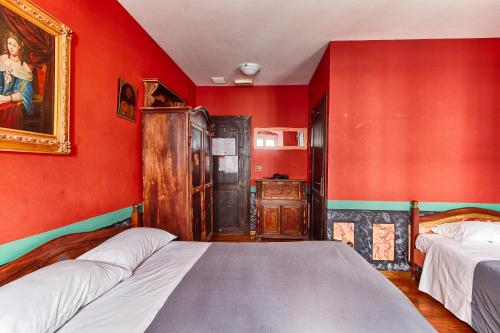 a bedroom with two beds and red walls at Hotel Portacavana in Trieste