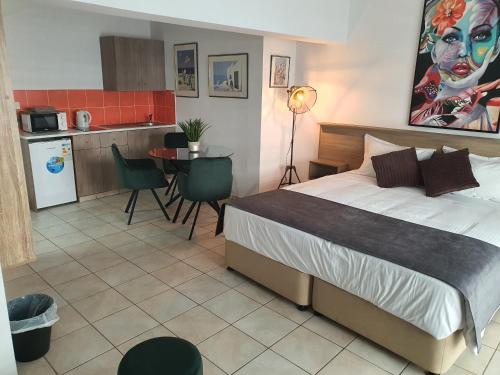 Cet appartement comprend une chambre avec un lit et une cuisine avec une table. dans l'établissement Larnaca Bay Suites, à Larnaka