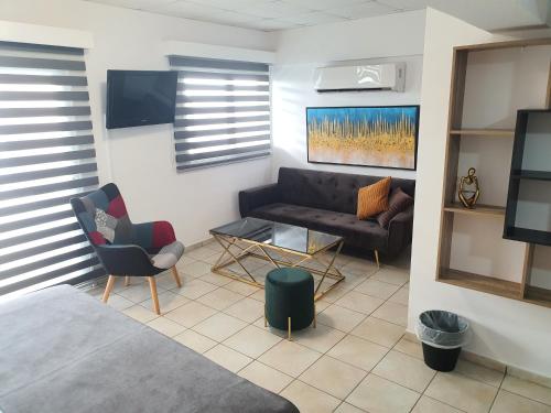 a living room with a couch and a table at Larnaca Bay Suites in Larnaka