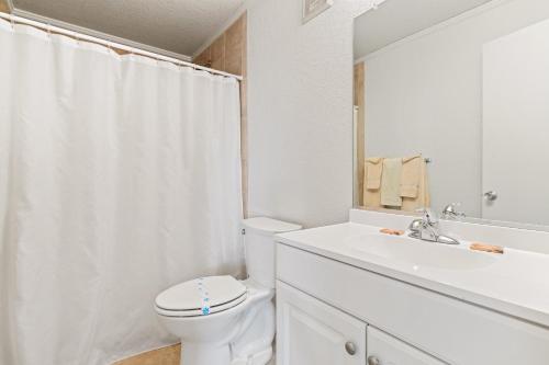 een witte badkamer met een toilet en een wastafel bij High Dunes in Kill Devil Hills