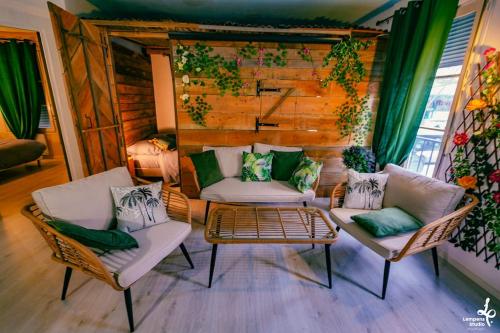 a living room with two chairs and a couch at Appartement la cabane du jardin (Troyes) in Troyes