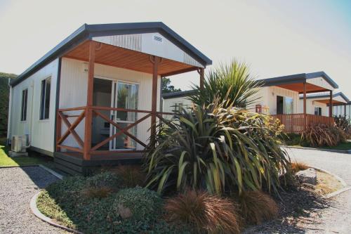 a small house with a porch and some plants at Taupo Debretts Spa Resort in Taupo