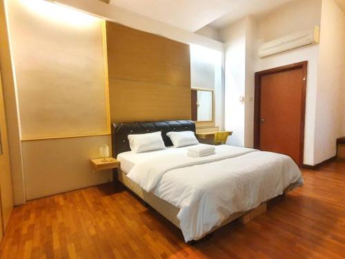 a bedroom with a large bed with a wooden floor at [HERITAGE 5] HOMESTAY Studio 4Pax, FREE WIFI in Seri Kembangan