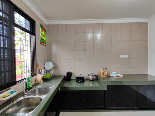 a kitchen with a sink and a counter top at Grand Height Homestay 3A 10pax 4Rooms in Sibu
