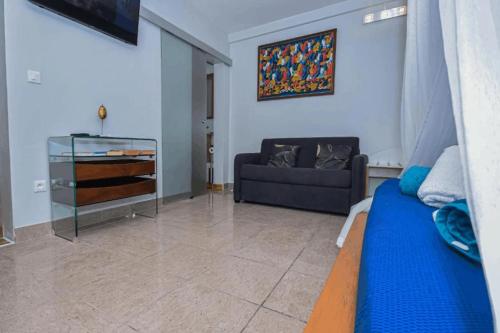 a living room with a blue bed and a couch at Redoute Paradise in Fort-de-France