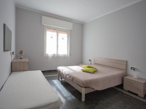 um quarto branco com 2 camas e uma janela em La Casetta Verde em Gênova