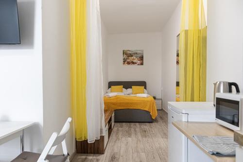 a small room with a bed with yellow curtains at Standard 3BR/3BA Apt. near Hauptbahnhof in Vienna