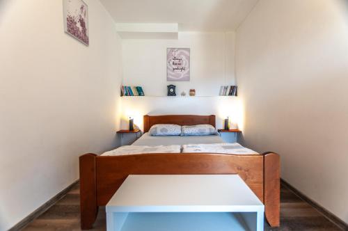 Dormitorio pequeño con cama y mesa en Apartments JULIA Bohinj, en Bohinj