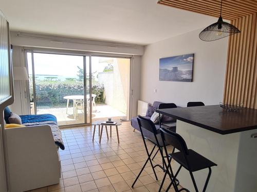 une cuisine et un salon avec une table et des chaises dans l'établissement Studio moderne RDC avec garage et terrasse - FR-1-550-21, à Saint-Georges-de-Didonne