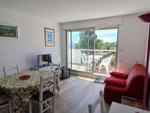 un salon avec un canapé rouge et une table dans l'établissement Appartement T2 à 150m de la plage avec parking - FR-1-550-22, à Vaux-sur-Mer