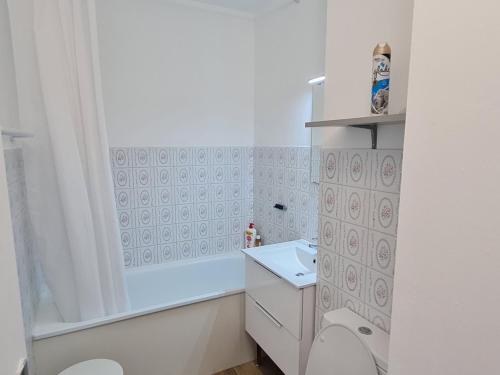 ein weißes Bad mit einem WC und einem Waschbecken in der Unterkunft Appartement Vaux-sur-Mer, 2 pièces, 4 personnes - FR-1-550-22 in Vaux-sur-Mer