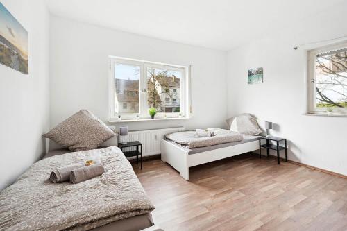 a white room with two beds and two windows at Monteurwohnungen am Neckar in Köngen