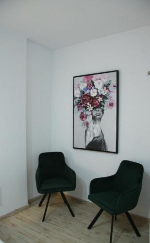 two chairs in a room with a picture on the wall at Larnaca Bay Suites in Larnaka