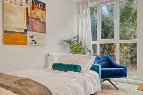 a bedroom with a bed and a blue chair and a window at Homely 1Bed Apartment Vauxhall in London