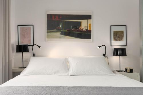 a bedroom with a bed with white sheets and two lamps at Apartment Pula Mon Amour in Pula