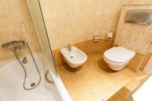 a bathroom with a toilet and a sink and a shower at Hotel Dauro Premier in Granada