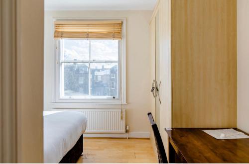 1 dormitorio con cama, escritorio y ventana en Beresford Road London Rooms, en Londres