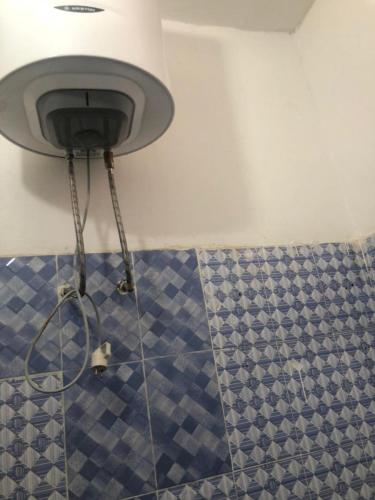 a shower in a bathroom with blue and white tiles at Al Amana in Dakar