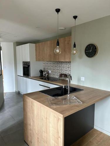 - une cuisine avec un comptoir, un évier et une horloge dans l'établissement Les Baigneuses Saint Brieuc centre avec parking, à Saint-Brieuc