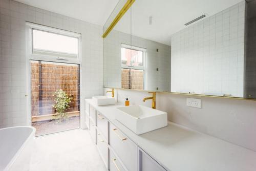 une salle de bains blanche avec deux lavabos et une fenêtre dans l'établissement SORRENTO ViLLA HOLLYWOOD, à Sorrento
