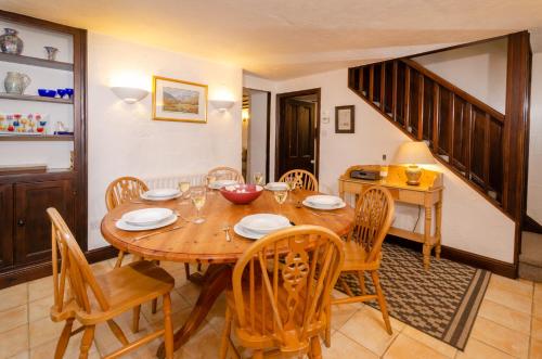 a dining room with a wooden table and chairs at Nans, Elterwater in Chapel Stile