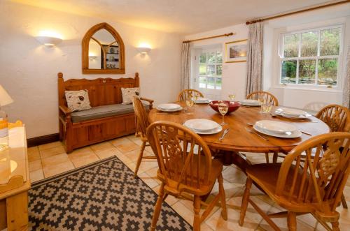 a dining room with a wooden table and chairs at Nans, Elterwater in Chapel Stile