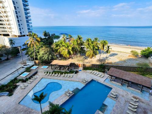 vistas a la piscina y a la playa en Apartamentos en Reserva del Mar - By BEDVIAJES, en Santa Marta