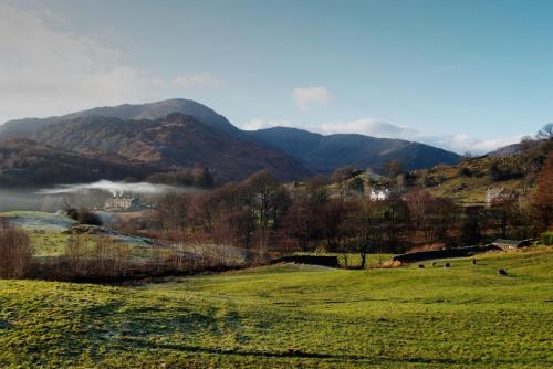 a green field with mountains in the background at Farra Grain, Little Langdale in Little Langdale