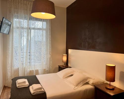 1 dormitorio con 1 cama y ventana con toallas en THC Gran Via Hostel en Madrid