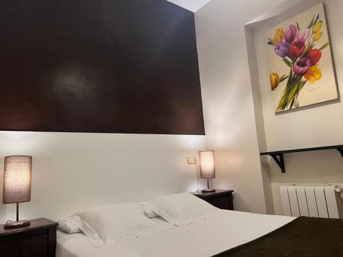 a bedroom with a bed with a painting on the wall at THC Gran Via Hostel in Madrid