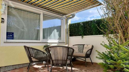 a patio with three chairs and a table and a window at Apartman Dino in Fažana