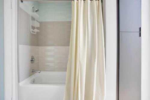 a bathroom with a white tub and a shower curtain at Hollywood 2BR w Roof BBQ nr MelroseFairfax LAX-890 in Los Angeles