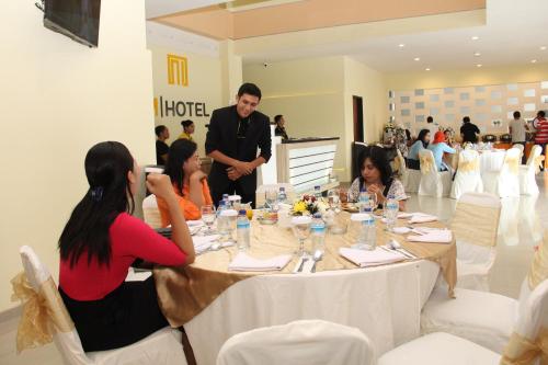 Un groupe de personnes assises autour d'une table dans une pièce dans l'établissement M Hotel, à Mataram
